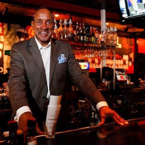 George Tinsley Sr. posed behind the bar of TGI Fridays.
